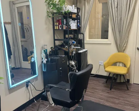 The styling chair in front of the lit mirror