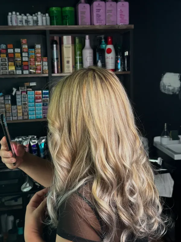 Blonde balayage curled from the mid lengths down, checked at the color bar