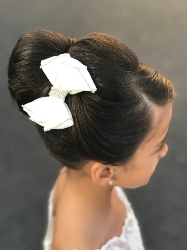 Flower girl updo finished with a white bow