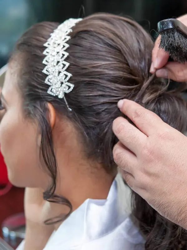 A crystal headband being worked into a braided bridal updo