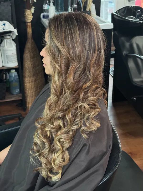 Honey balayage on a dark base, finished in tight curls to the waist