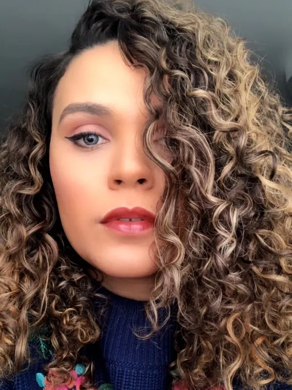 Balayage placed to follow the curl pattern, so the color reads in the coil and not in a line